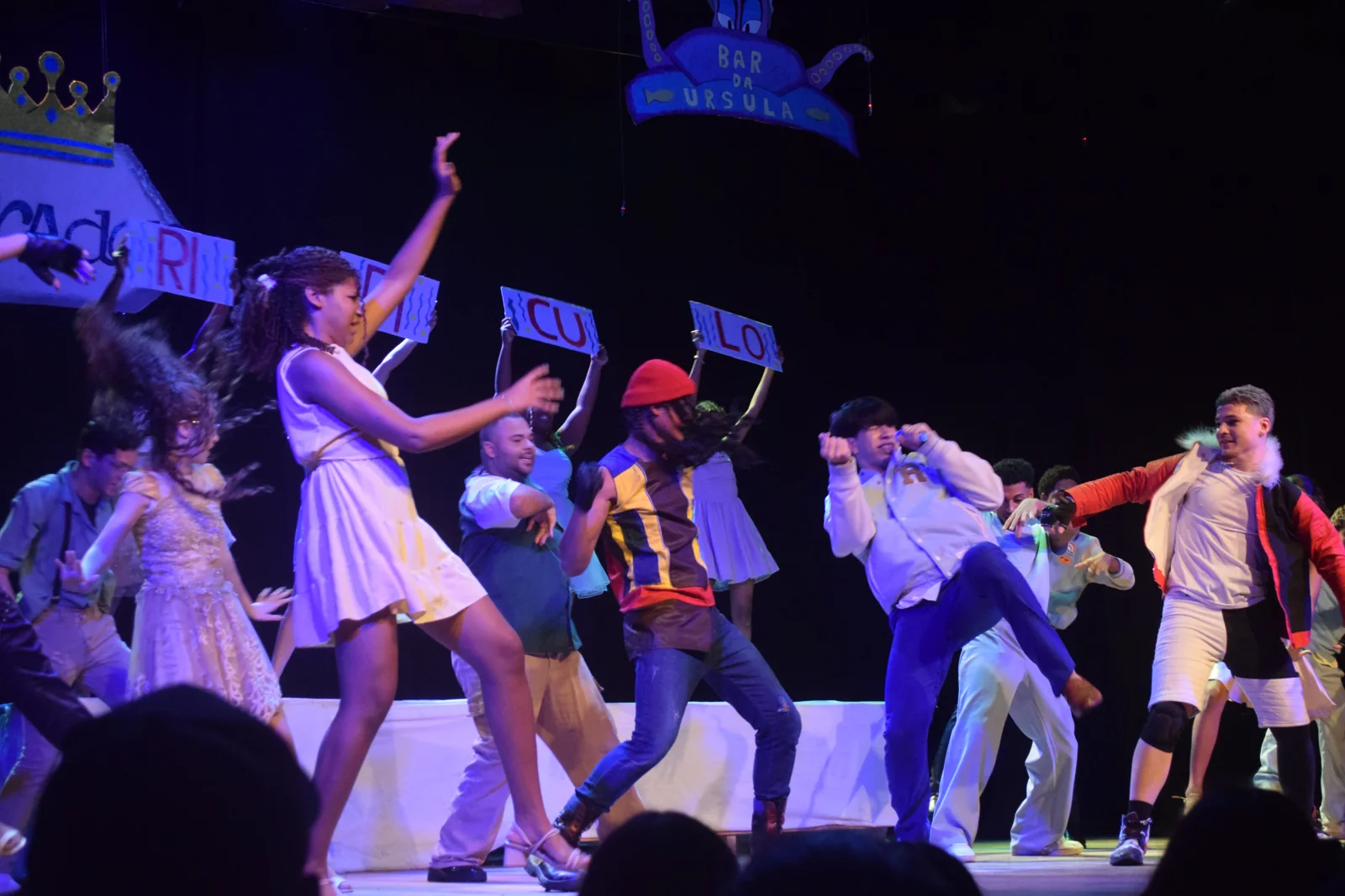 Artistas da Semearte dançando no palco sob luzes azuis